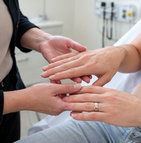 Medical student examining a patient’s hands for respiratory signs